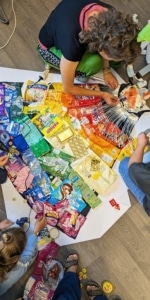 Kinder beim Basteln von Superheld*innen Kostümen aus Recyclingmaterial